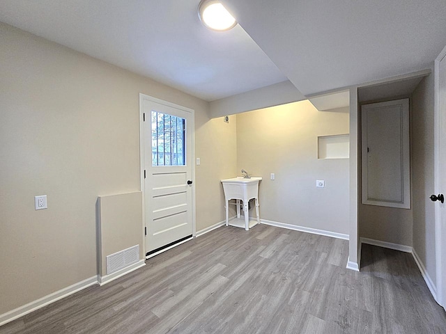 laundry room featuring sink and light wood-type flooring