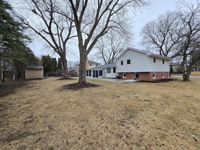 view of yard featuring a storage shed, a sunroom, and a patio