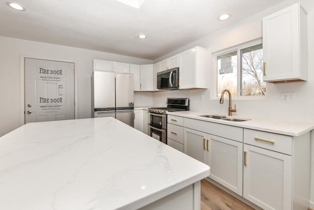 kitchen featuring stainless steel appliances, sink, and white cabinets