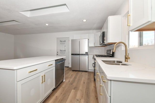 kitchen featuring sink, light hardwood / wood-style flooring, white cabinets, and appliances with stainless steel finishes