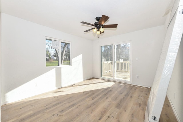 empty room with ceiling fan and light hardwood / wood-style flooring