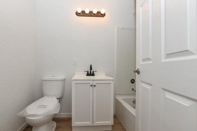 bathroom featuring vanity, a washtub, toilet, and hardwood / wood-style flooring