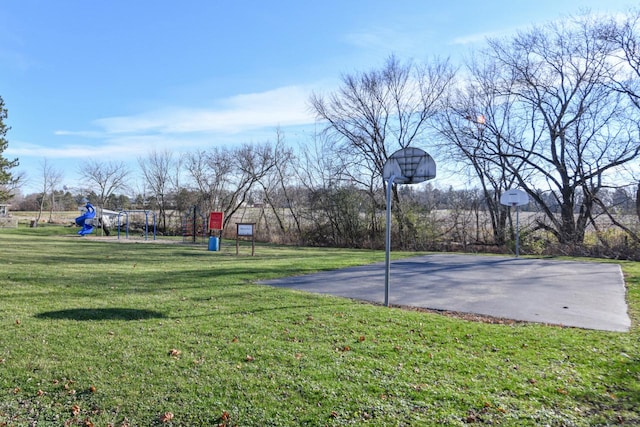 view of basketball court with a playground and a yard