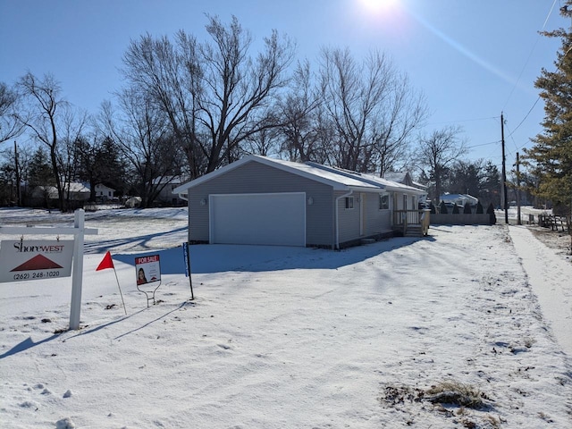 snow covered property featuring a garage