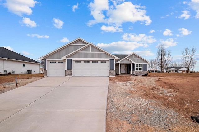 craftsman inspired home with a garage, stone siding, concrete driveway, and central air condition unit