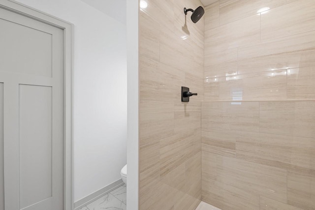 bathroom featuring tiled shower and toilet