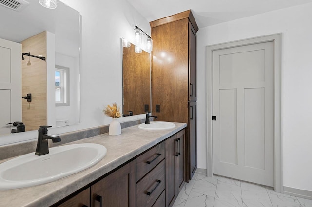 bathroom with marble finish floor, visible vents, a sink, and walk in shower