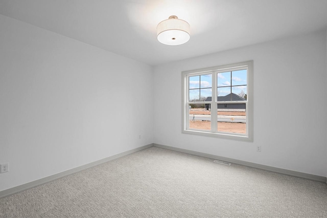 spare room featuring visible vents, baseboards, and carpet flooring