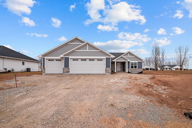 craftsman inspired home with stone siding, central AC, driveway, and an attached garage