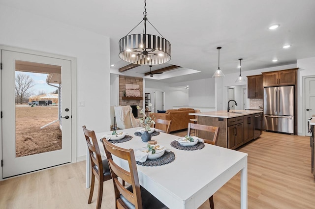 dining area featuring a chandelier, recessed lighting, and light wood-style flooring