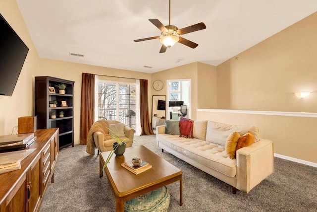 carpeted living room with ceiling fan and vaulted ceiling