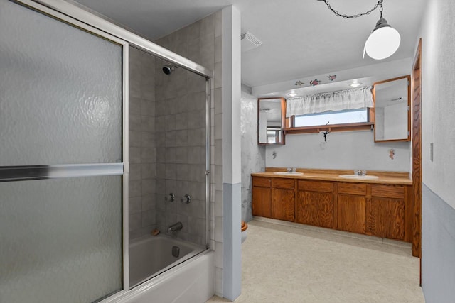 bathroom with vanity and shower / bath combination with glass door