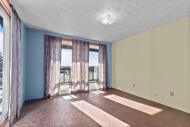 unfurnished room with a textured ceiling