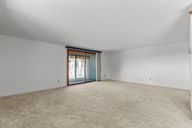 carpeted empty room featuring a textured ceiling