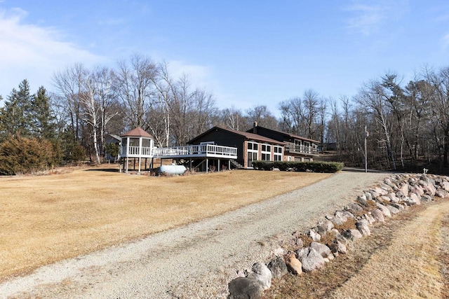 view of front facade featuring a deck and a front yard