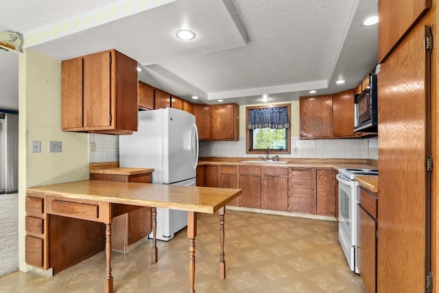 kitchen with sink, white appliances, decorative backsplash, and a textured ceiling