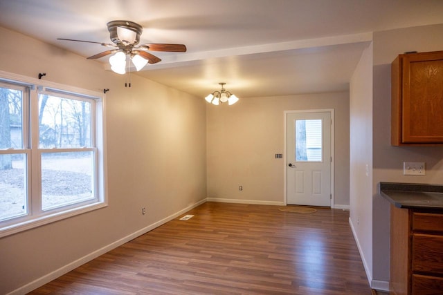 interior space with ceiling fan with notable chandelier and hardwood / wood-style floors