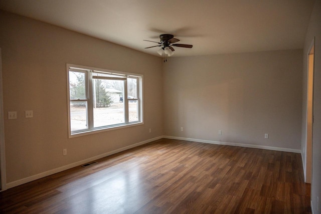 spare room with dark wood-type flooring and ceiling fan