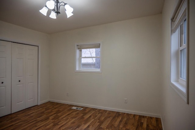 unfurnished bedroom featuring dark wood-type flooring and a closet