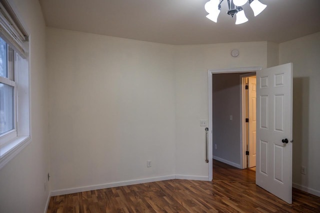 unfurnished room with dark wood-type flooring