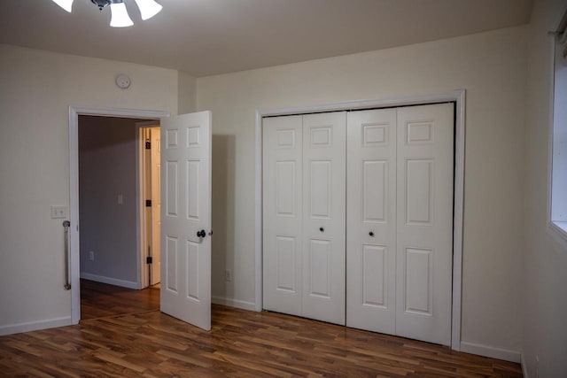 unfurnished bedroom with dark hardwood / wood-style floors and a closet