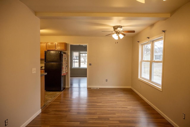 spare room with wood-type flooring, a healthy amount of sunlight, and ceiling fan