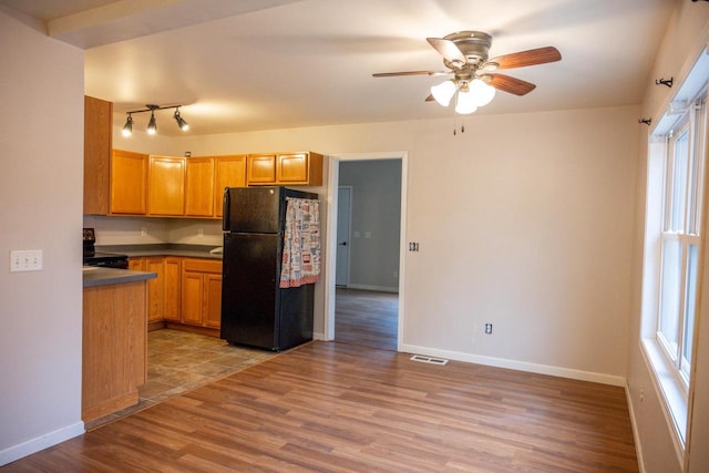 kitchen featuring black fridge, ceiling fan, light hardwood / wood-style floors, and electric range