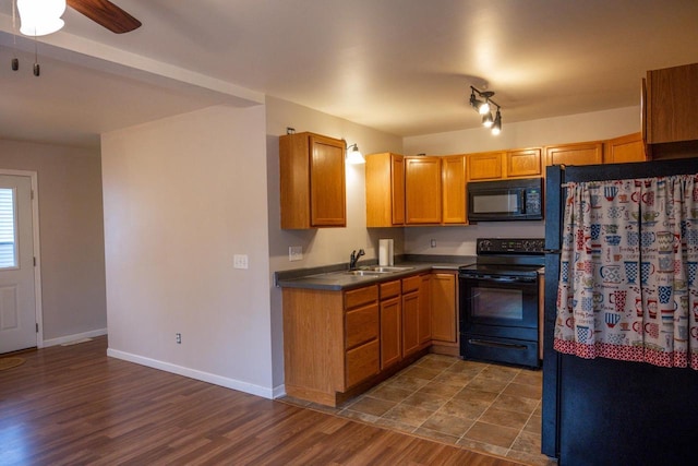 kitchen with ceiling fan, dark hardwood / wood-style floors, sink, and black appliances