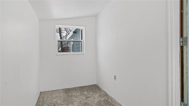 unfurnished room with lofted ceiling and light carpet