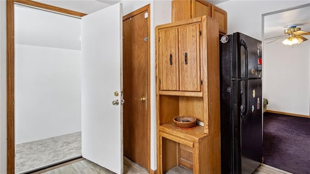 interior space with black refrigerator and ceiling fan