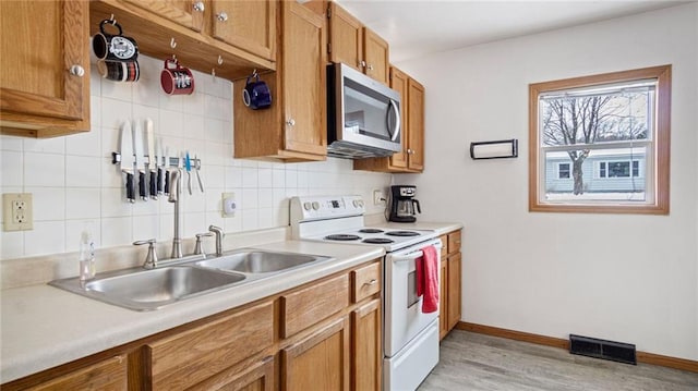 kitchen with tasteful backsplash, sink, light hardwood / wood-style flooring, and white electric range oven