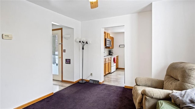 sitting room featuring light colored carpet and ceiling fan