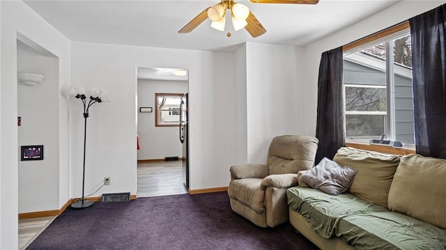 living area featuring carpet and ceiling fan