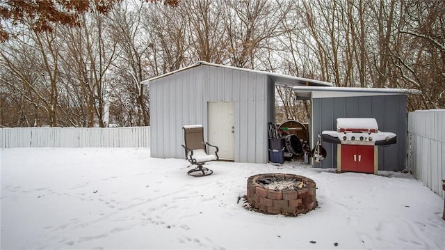 snow covered structure featuring an outdoor fire pit