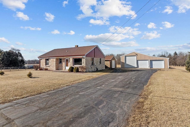 single story home with an outbuilding, a garage, and a front lawn