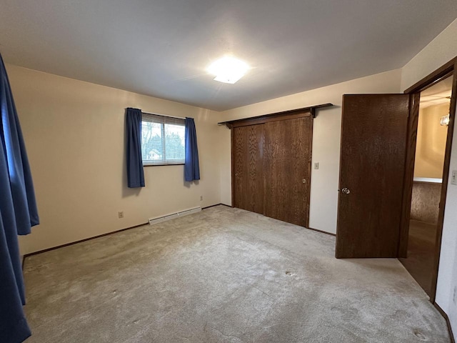 unfurnished bedroom with baseboard heating, light colored carpet, and a closet