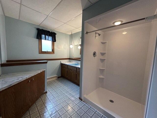 bathroom with vanity, a paneled ceiling, and a shower