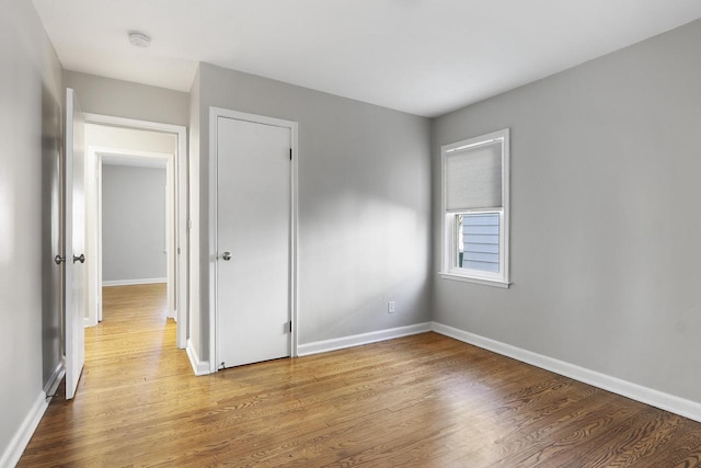 unfurnished bedroom with wood-type flooring and a closet