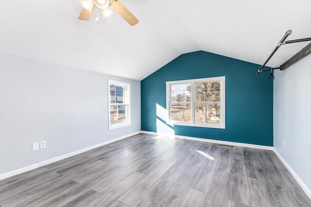 spare room featuring ceiling fan, lofted ceiling, and light hardwood / wood-style floors