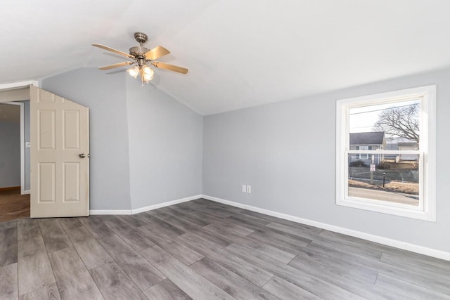 additional living space with hardwood / wood-style floors, vaulted ceiling, and ceiling fan