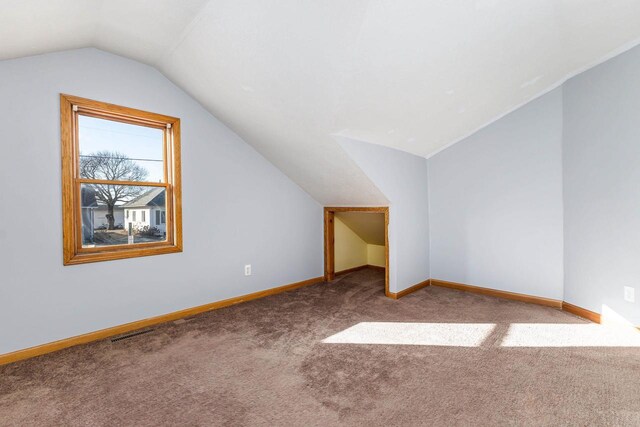 additional living space featuring lofted ceiling and carpet floors