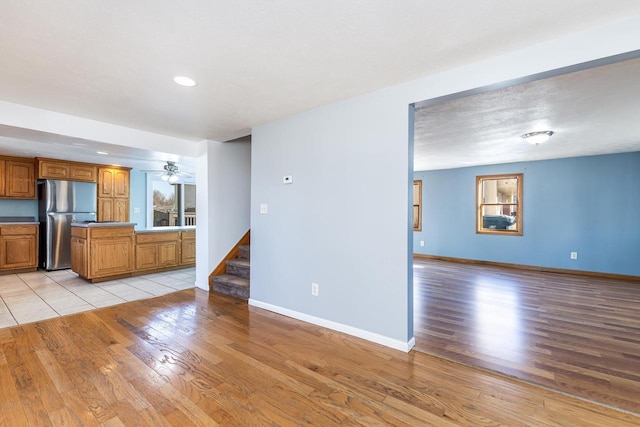 kitchen featuring stainless steel refrigerator, ceiling fan, and light wood-type flooring