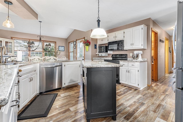 kitchen featuring a kitchen island, white cabinetry, hanging light fixtures, light stone counters, and black appliances