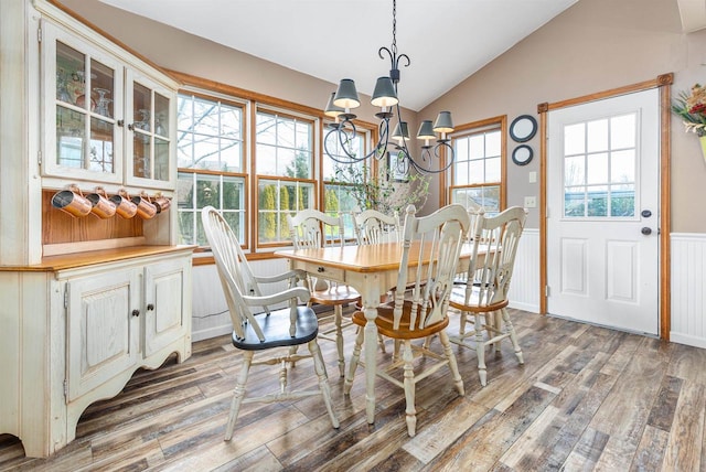 dining room featuring a notable chandelier, hardwood / wood-style flooring, and vaulted ceiling