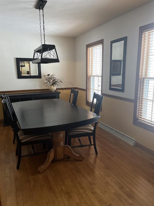 dining room featuring a wealth of natural light, a baseboard radiator, and wood-type flooring