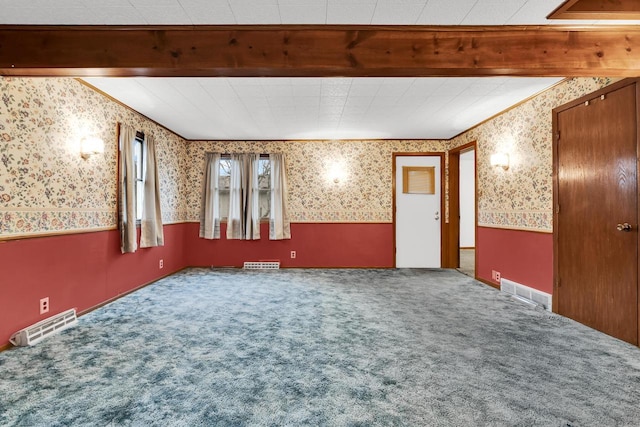 unfurnished room featuring beam ceiling and carpet floors