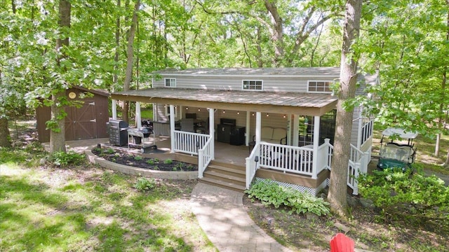 view of front of house featuring covered porch and a storage unit