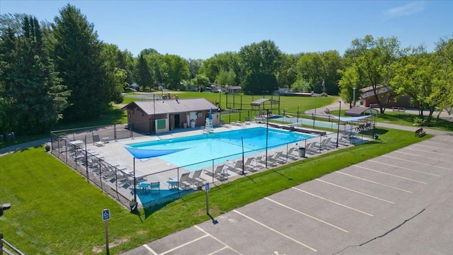 view of pool featuring a patio and a yard