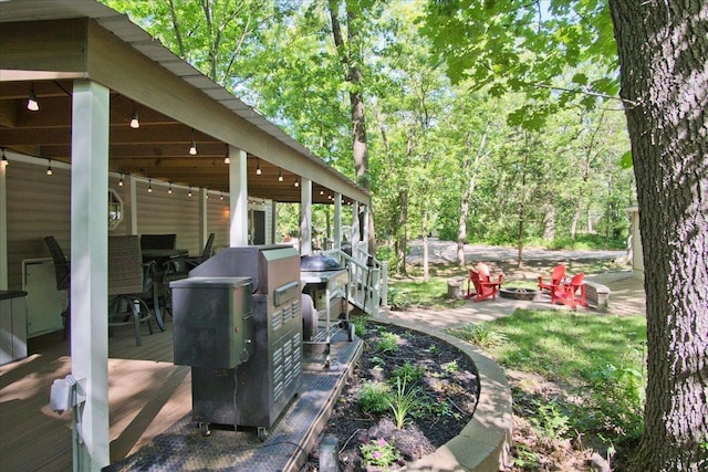 view of yard with a wooden deck and an outdoor fire pit