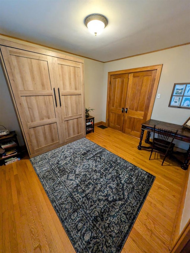 entryway featuring hardwood / wood-style flooring and crown molding